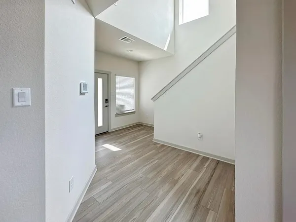 a view of a hallway with wooden floor and staircase