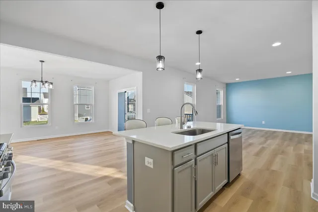 a kitchen with a sink a mirror and wooden floor
