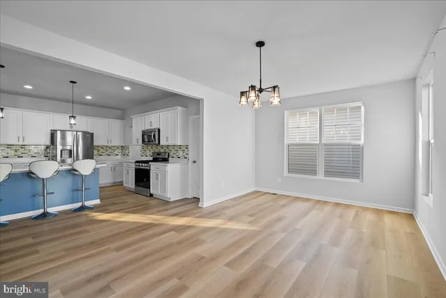 a view of kitchen with granite countertop cabinets and refrigerator