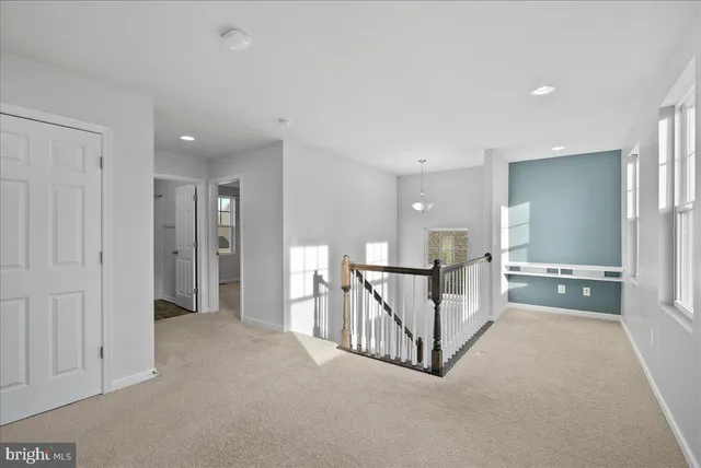 a view of a hallway with a tv and stairs