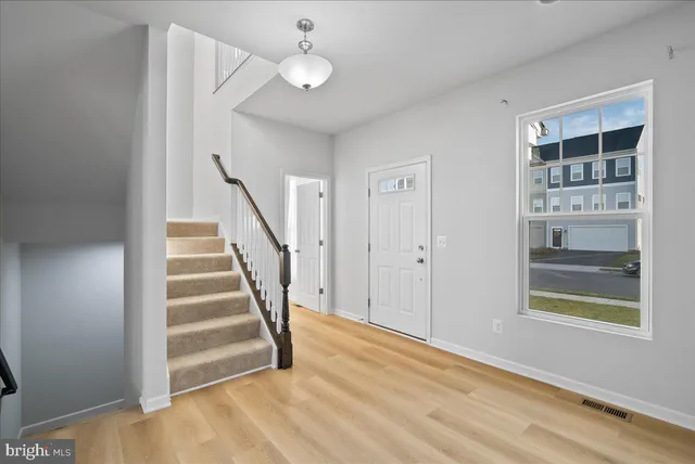 a view of entryway and hall with wooden floor
