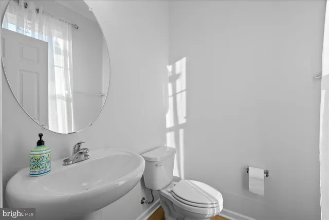 a bathroom with a sink a toilet and a mirror