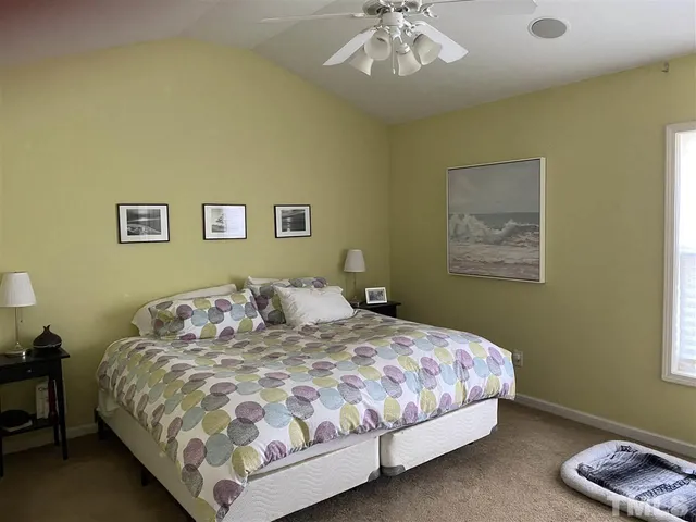 a large bed sitting in a bedroom next to a window