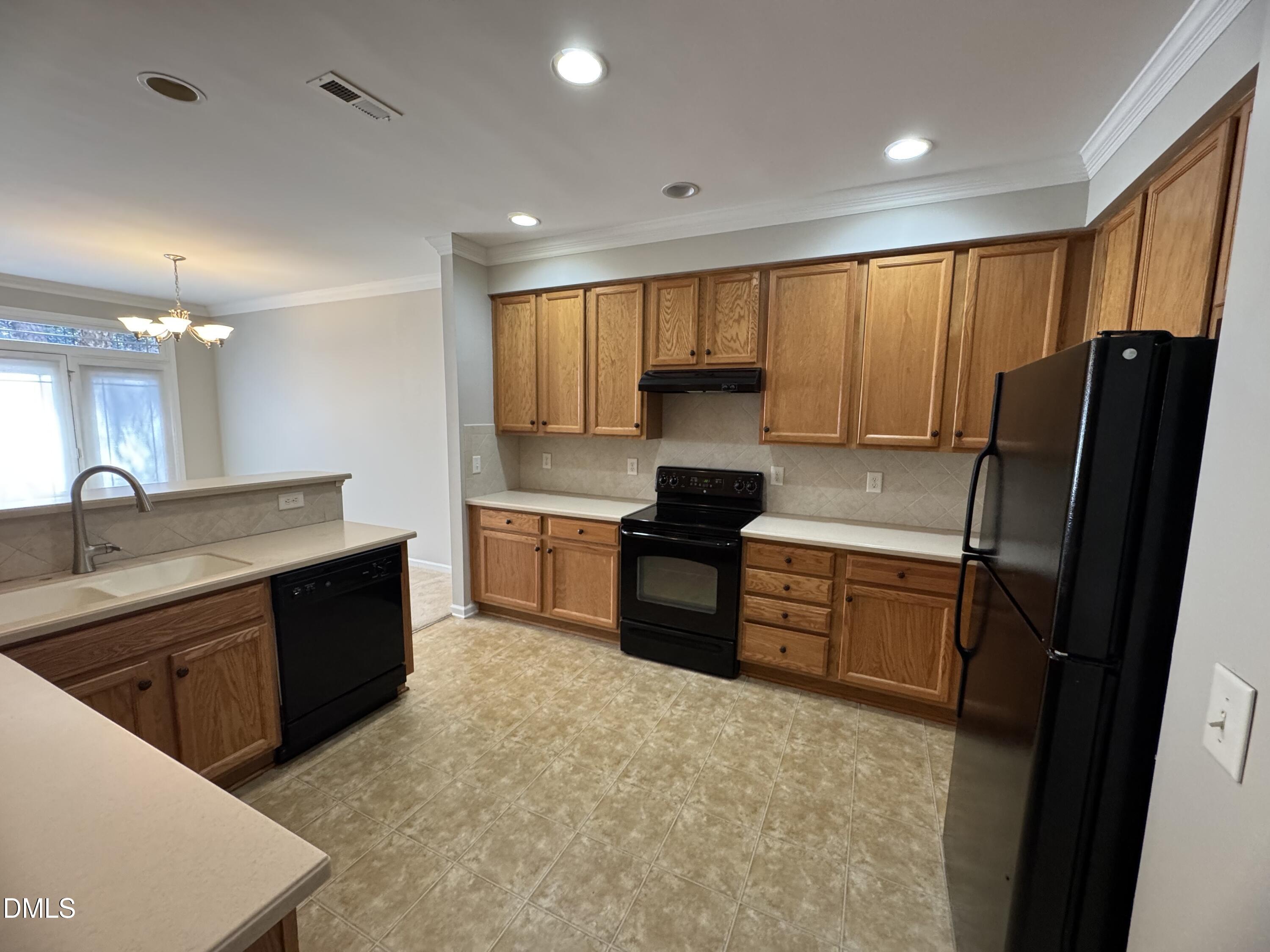 4705 Lawhorn Street Raleigh, NC 27606 - Photo 3 of 13 a large kitchen with a large counter top sink appliances and cabinets