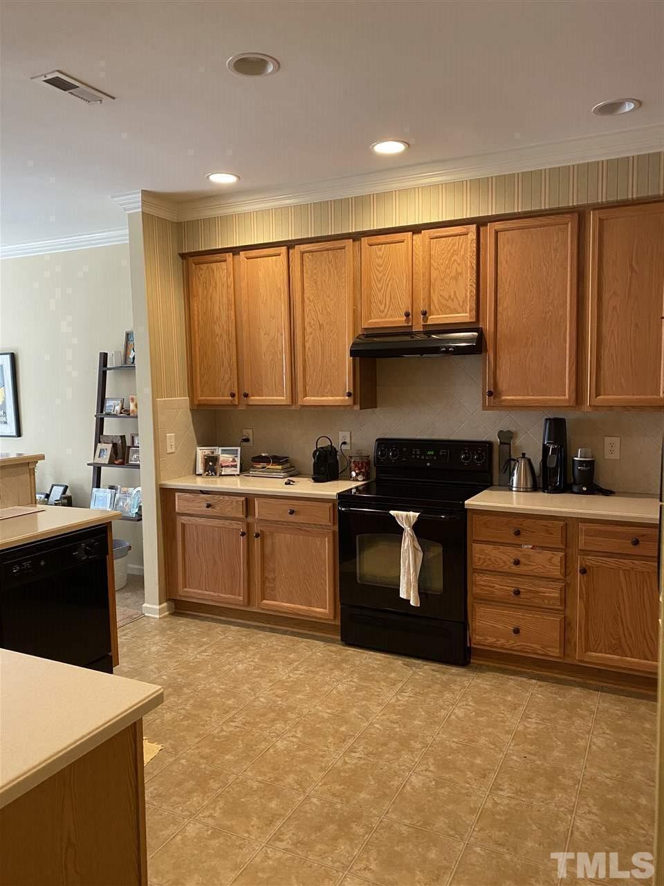 4705 Lawhorn Street Raleigh, NC 27606 - Photo 6 of 9 a kitchen with stainless steel appliances kitchen island granite countertop a stove a sink and a refrigerator