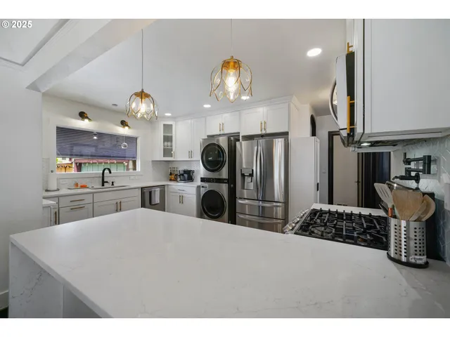 a kitchen with kitchen island granite countertop a sink a stove and refrigerator
