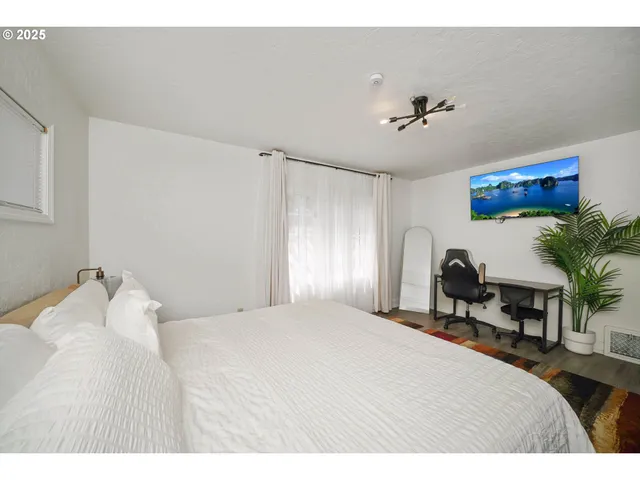 a bedroom with a large bed and a chandelier