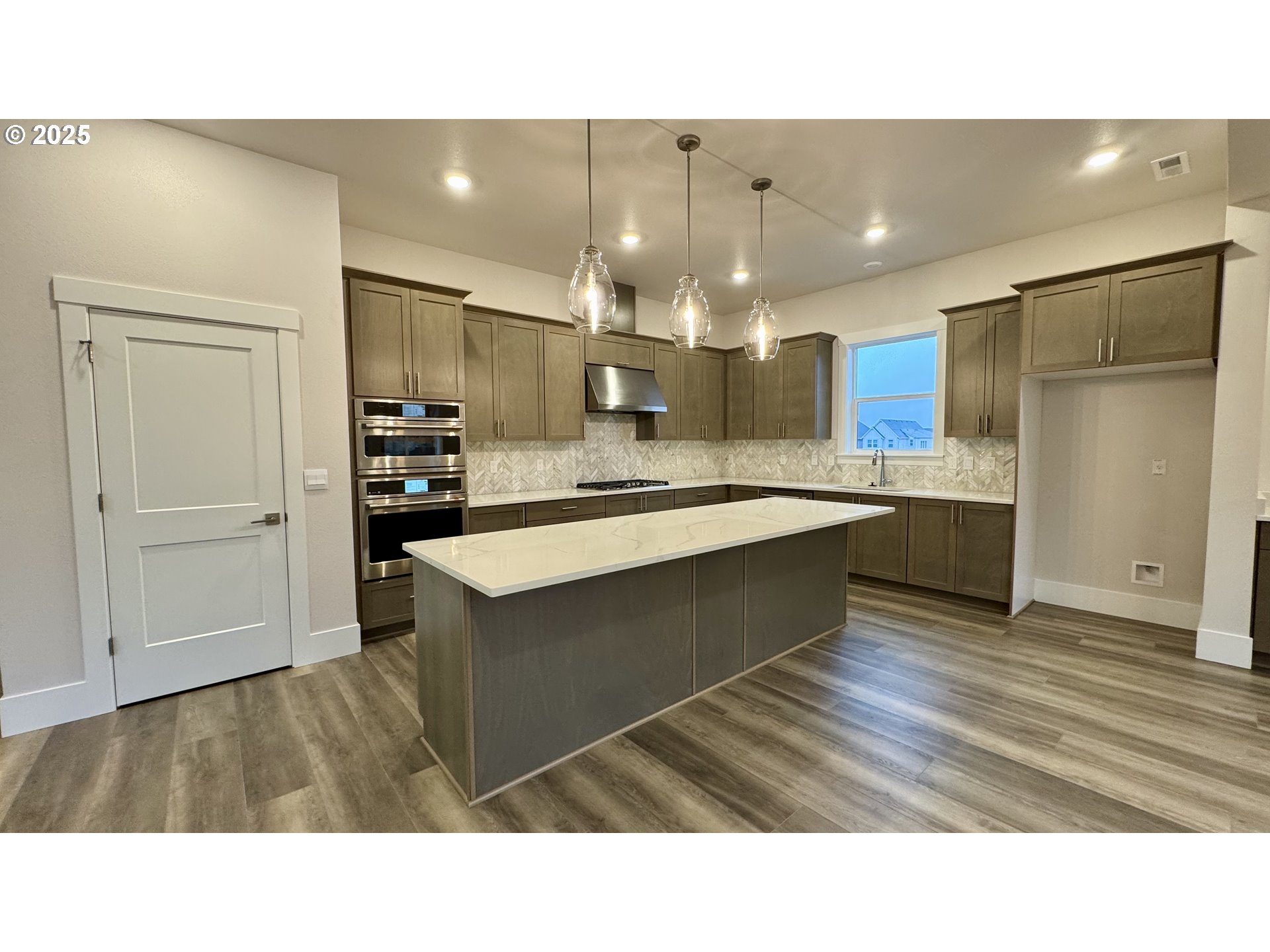 11728 Southwest Hayrick Terrace Beaverton, OR 97007 - Photo 13 of 25 a kitchen with kitchen island a sink stainless steel appliances and cabinets