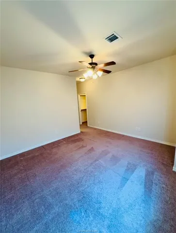 an empty room with a window and a ceiling fan