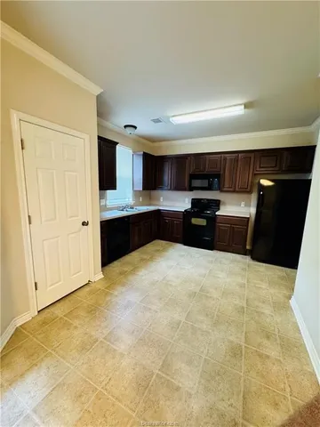 a large kitchen with stainless steel appliances a large counter top