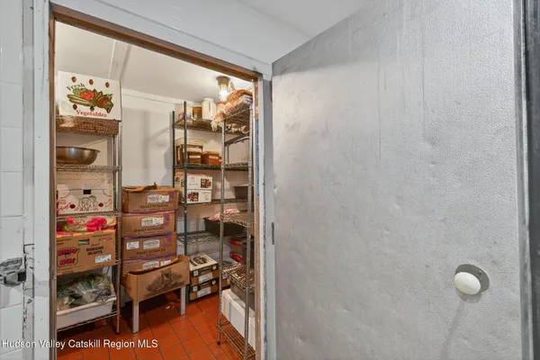 a view of a hallway with wooden floor and a bathroom