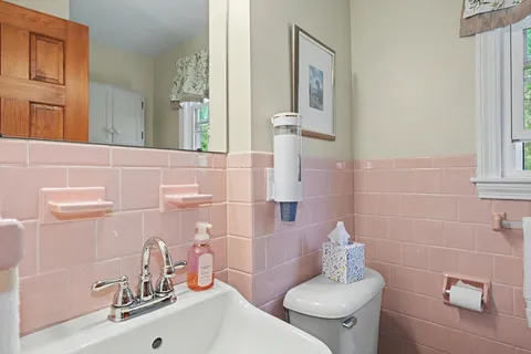 a bathroom with a sink a toilet and mirror