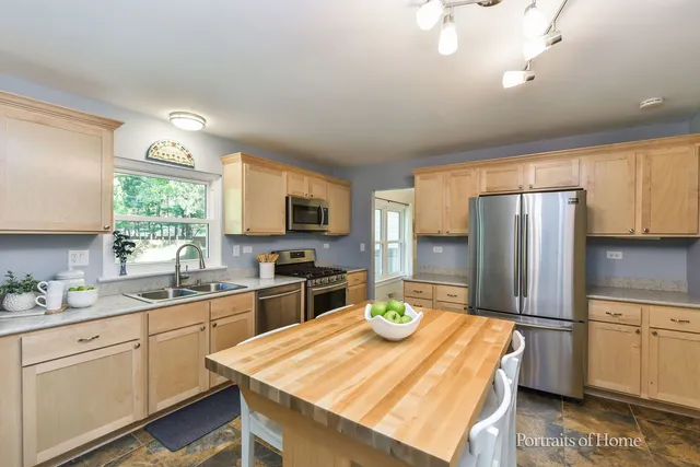 a kitchen with a sink a kitchen island and stainless steel appliances