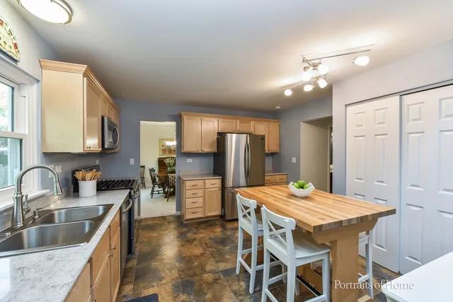 a kitchen with a table chairs sink and refrigerator