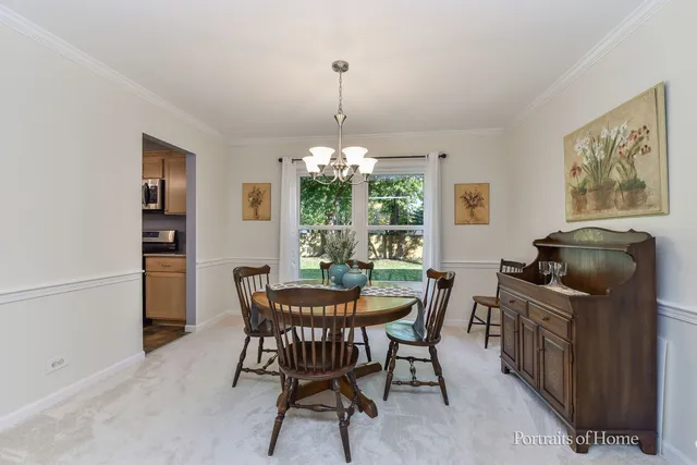 a dining room with furniture a chandelier and window