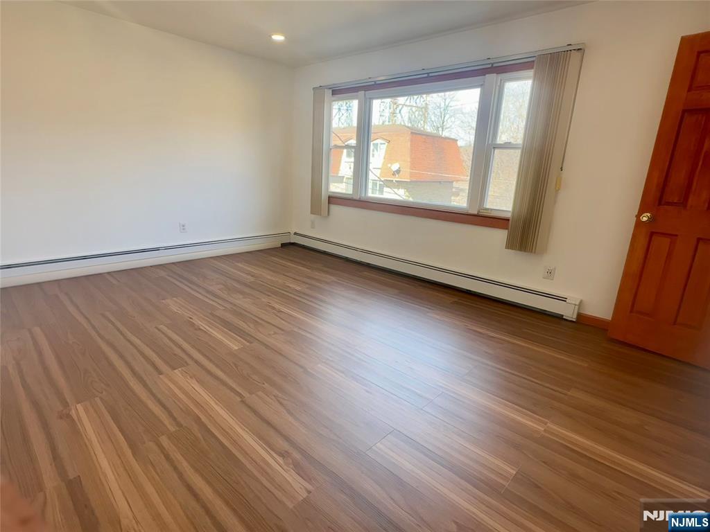 17 Hamilton Street Harrison, NJ 07029 - Photo 3 of 11 an empty room with wooden floor and windows