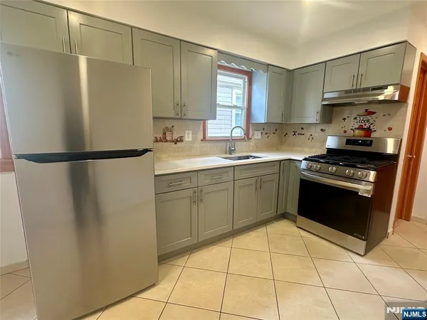 a kitchen with stainless steel appliances a refrigerator sink and cabinets
