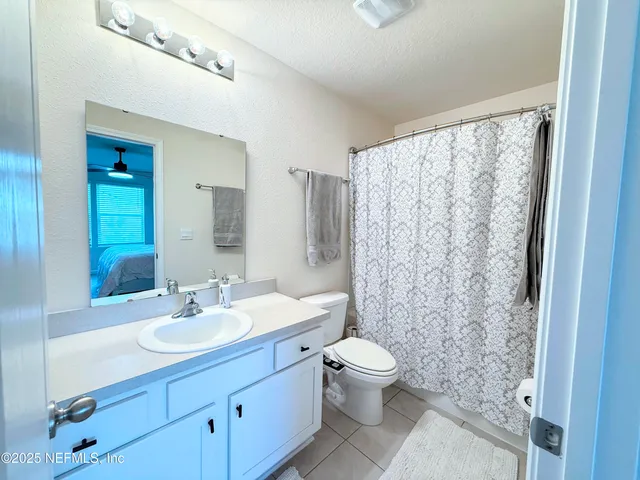 a bathroom with a sink toilet a mirror and shower curtain
