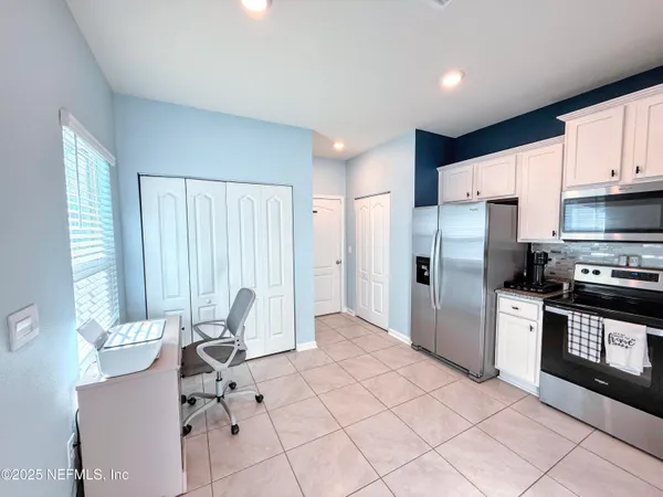 a kitchen with stainless steel appliances kitchen island granite countertop a refrigerator and a stove top oven
