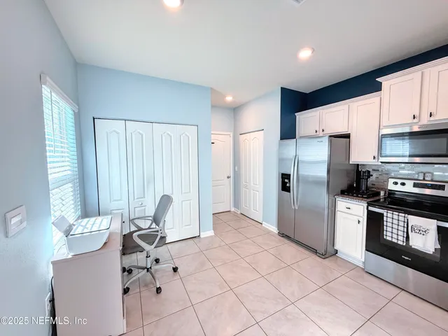 a kitchen with stainless steel appliances kitchen island granite countertop a refrigerator and a stove top oven