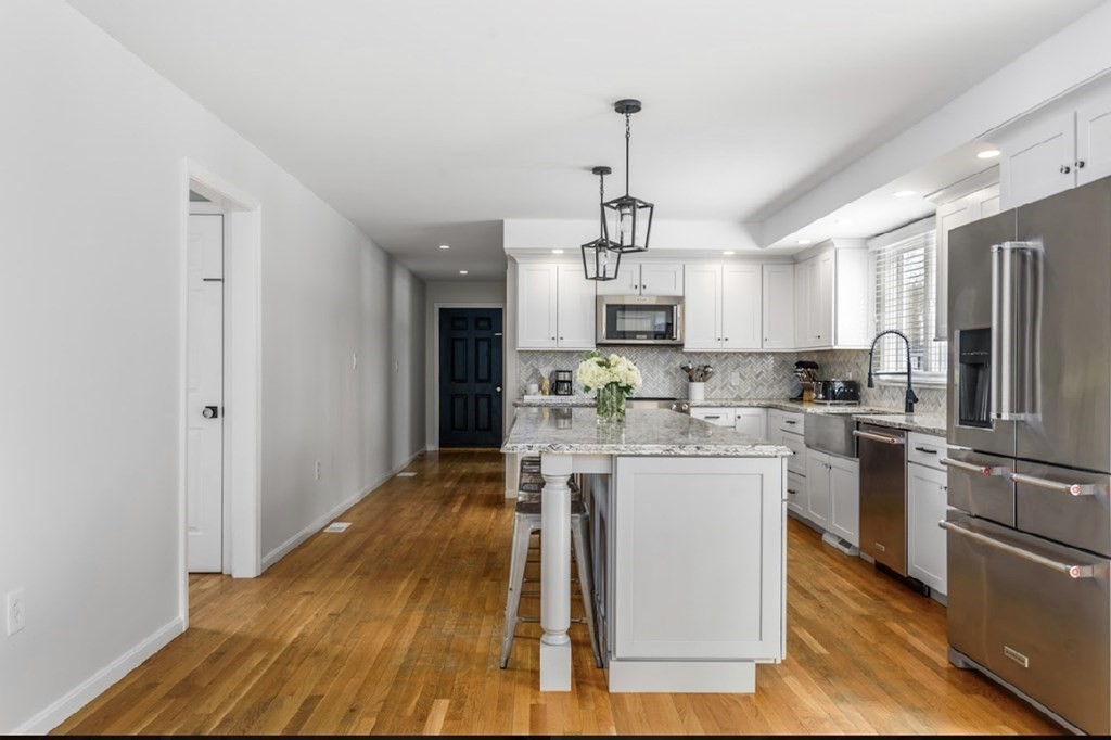 11 Woodman Road Amesbury, MA 01913 - Photo 6 of 31 a view of a kitchen with center island and stainless steel appliances