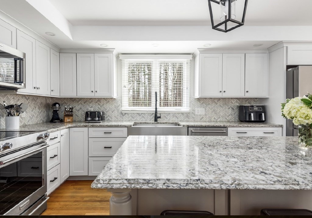 11 Woodman Road Amesbury, MA 01913 - Photo 7 of 31 a kitchen with granite countertop a sink stainless steel appliances and cabinets