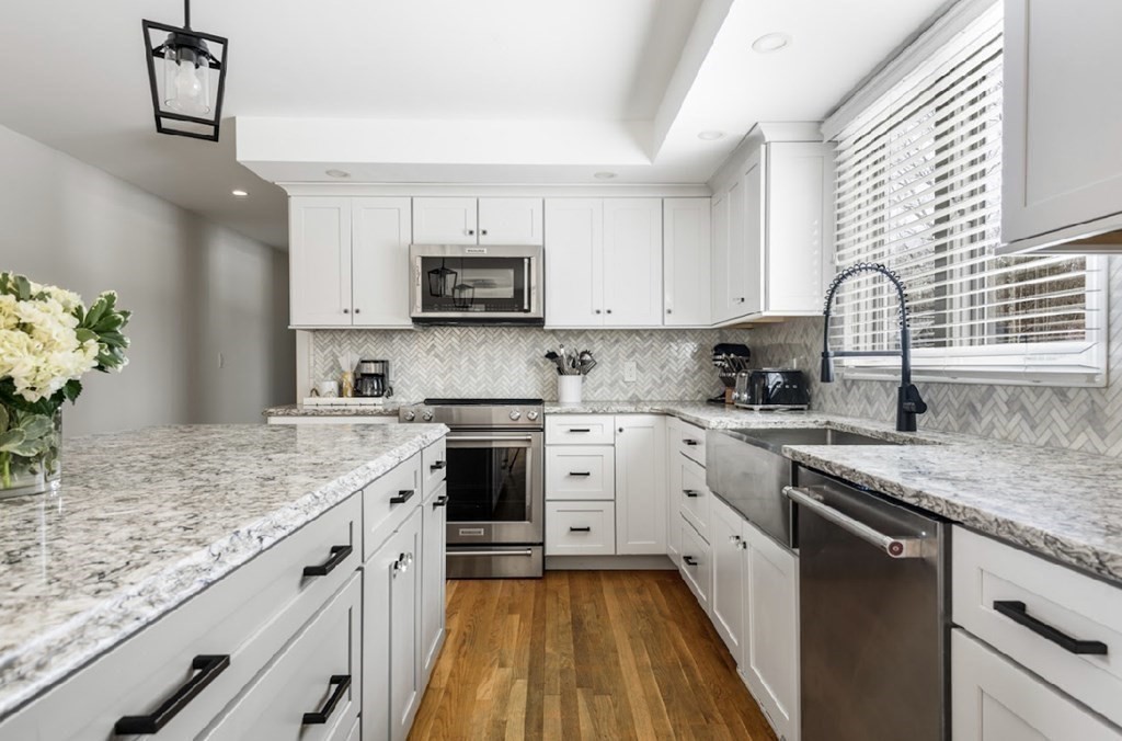 11 Woodman Road Amesbury, MA 01913 - Photo 8 of 31 a kitchen with stainless steel appliances granite countertop a sink a stove top oven a counter space and cabinets