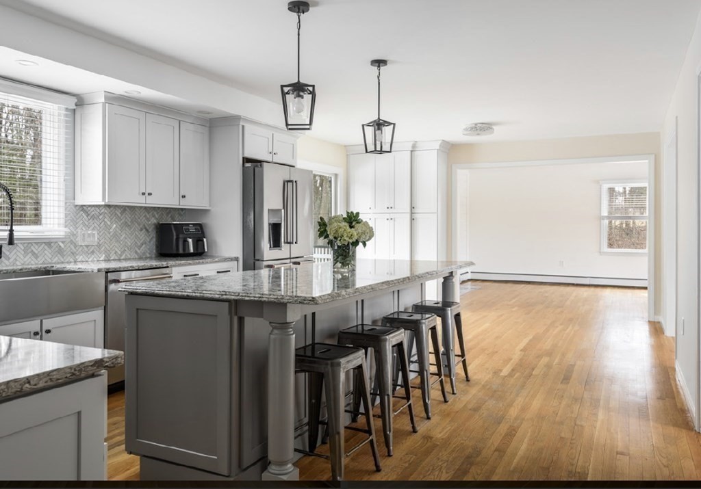 11 Woodman Road Amesbury, MA 01913 - Photo 9 of 31 a kitchen with stainless steel appliances granite countertop a dining table chairs refrigerator and microwave