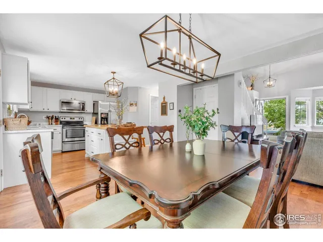 a dining room filled chandelier and kitchen view