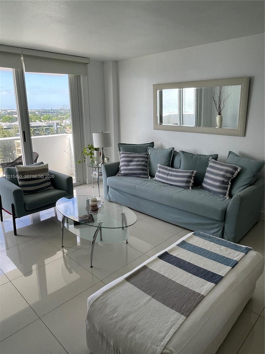 a living room with furniture and floor to ceiling windows