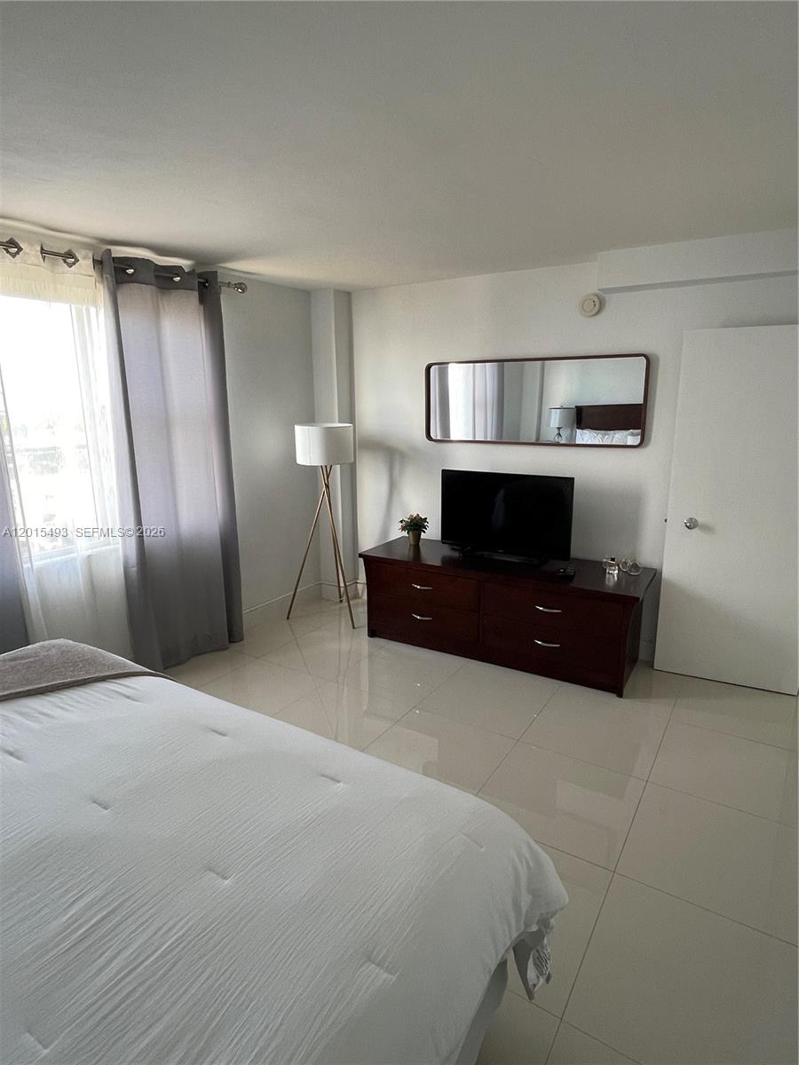 9195 Collins Avenue, Unit 1012 Surfside, FL 33154 - Photo 11 of 27 a living room with a couch and a cabinet