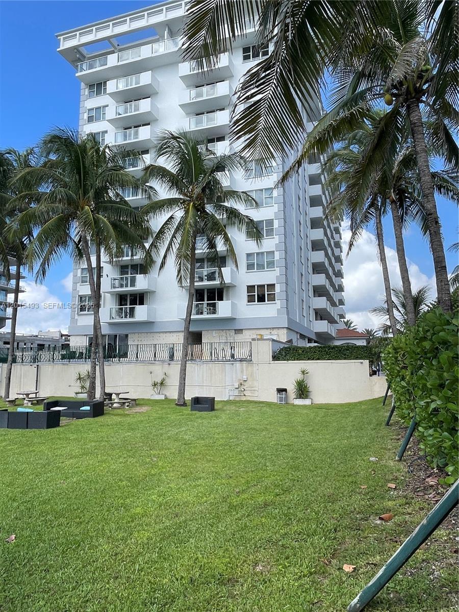 9195 Collins Avenue, Unit 1012 Surfside, FL 33154 - Photo 19 of 27 a front view of a house with swimming pool and a garden