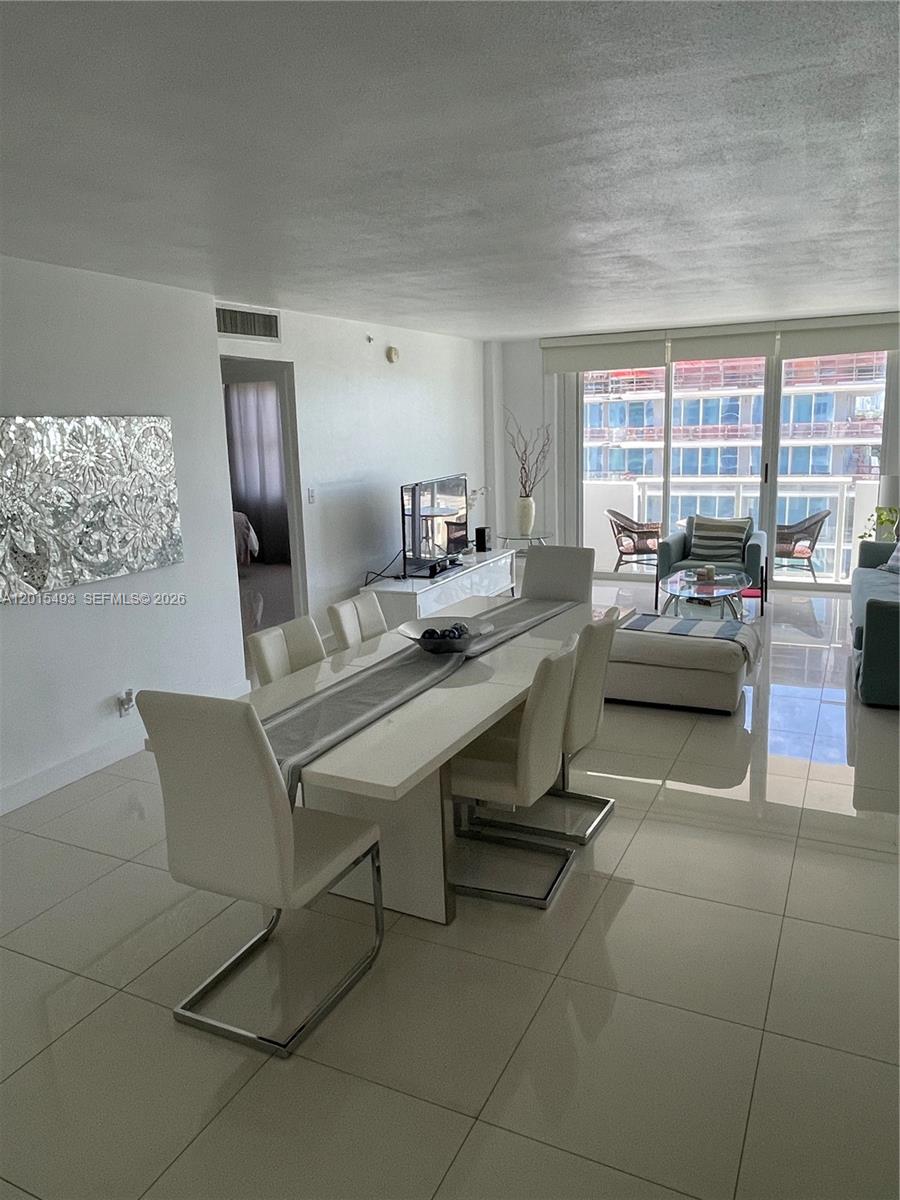 9195 Collins Avenue, Unit 1012 Surfside, FL 33154 - Photo 4 of 27 a work room with furniture and large windows