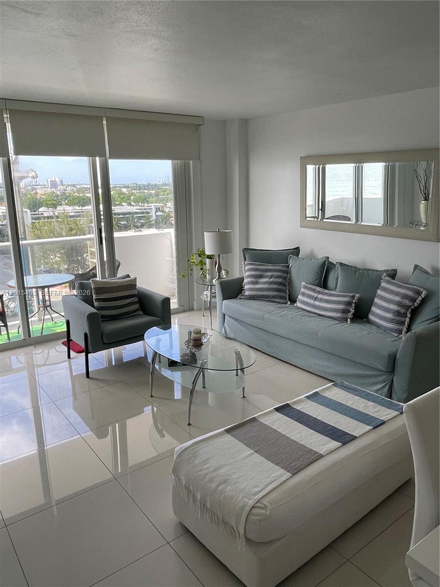 9195 Collins Avenue, Unit 1012 Surfside, FL 33154 - Photo 6 of 27 a living room with furniture and large windows