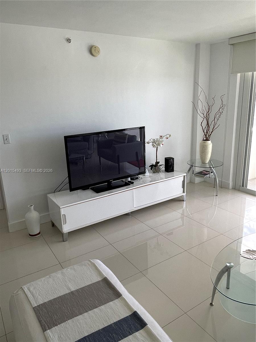 9195 Collins Avenue, Unit 1012 Surfside, FL 33154 - Photo 7 of 27 a living room with furniture and a couch