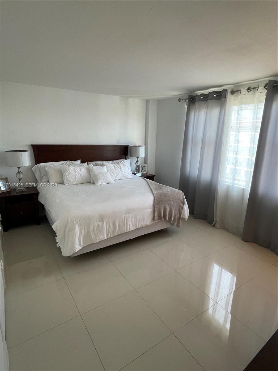 9195 Collins Avenue, Unit 1012 Surfside, FL 33154 - Photo 10 of 27 a bedroom with a bed and window
