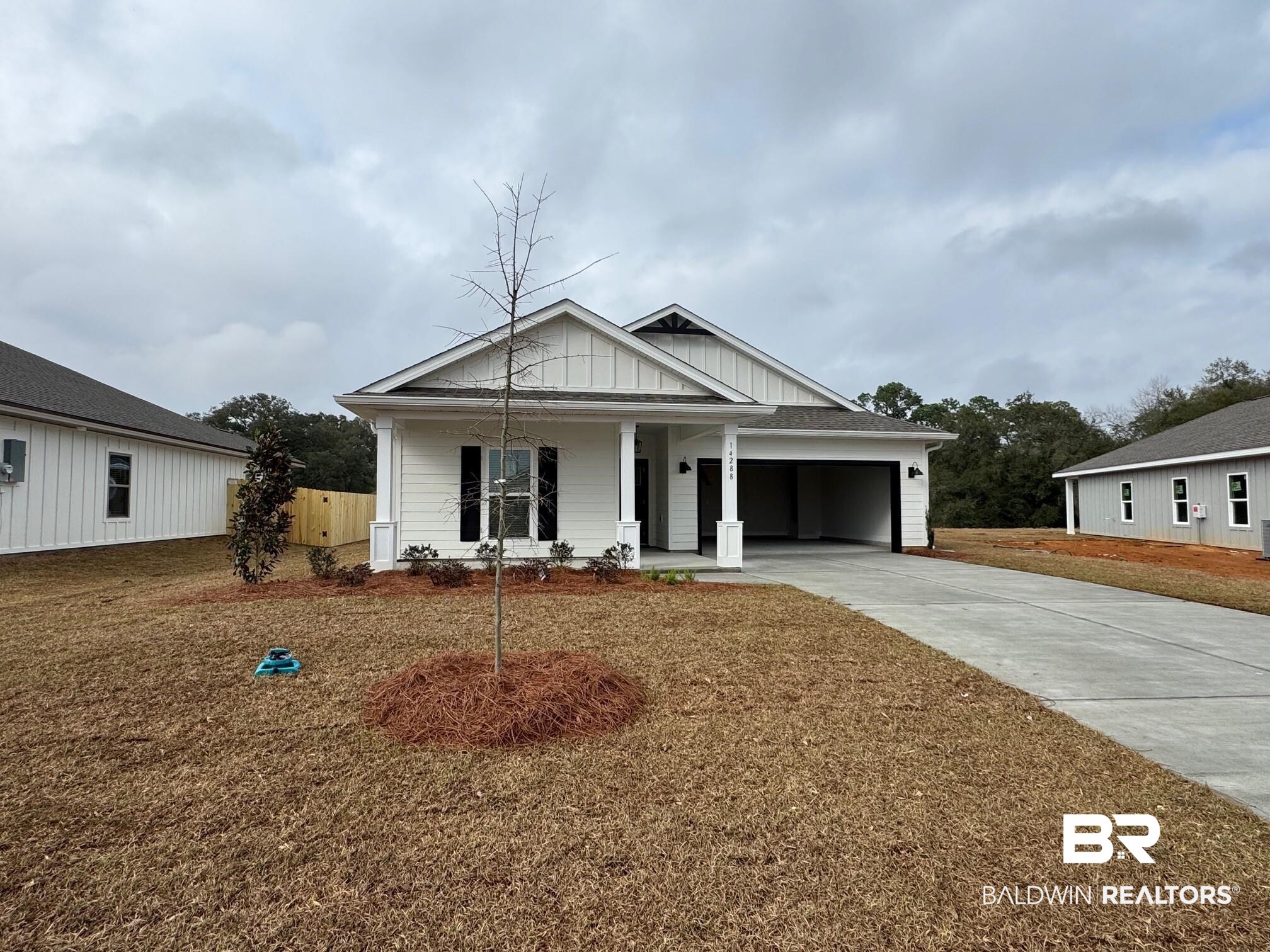 14288 Versailles Circle Silverhill, AL 36576 - Photo 1 of 31 View of front facade featuring driveway, covered porch, board and batten siding, and a garage