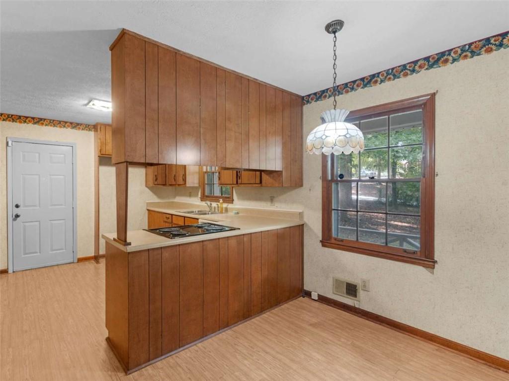 8294 Winston Way Jonesboro, GA 30236 - Photo 14 of 67 a kitchen with stainless steel appliances granite countertop a refrigerator a sink dishwasher a stove and a dining table with wooden floor