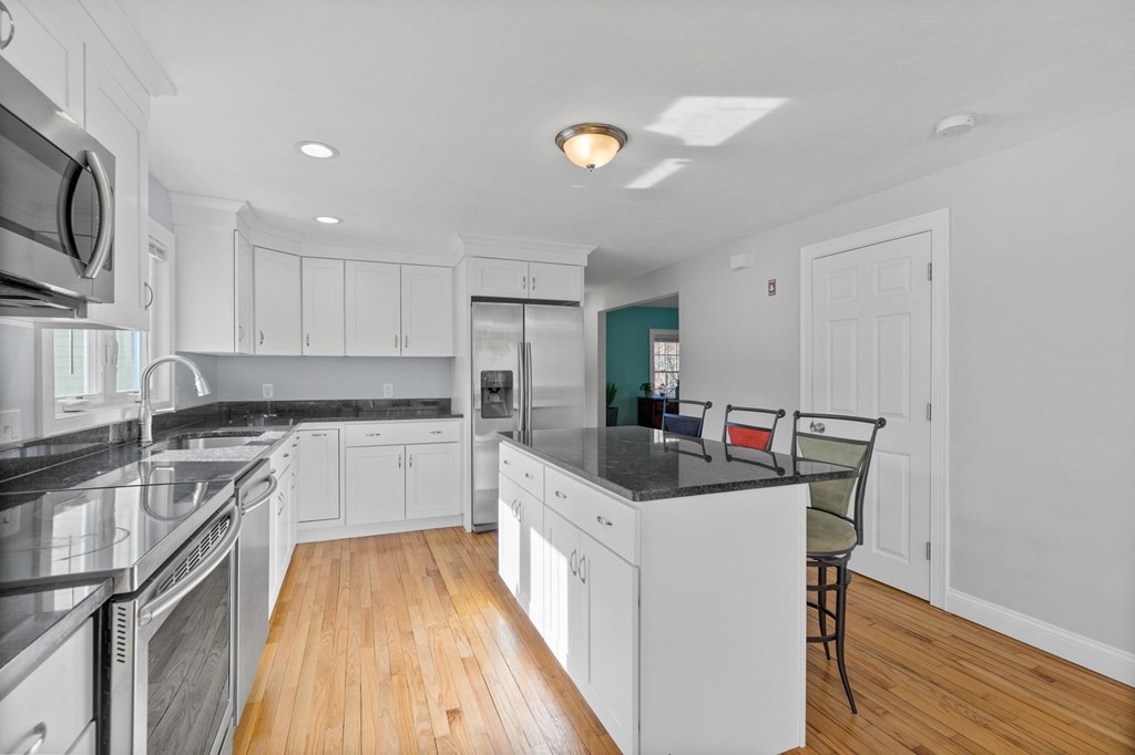 37 Lincoln Street Norton, MA 02766 - Photo 5 of 42 a kitchen with a sink dishwasher stove and white cabinets with wooden floor