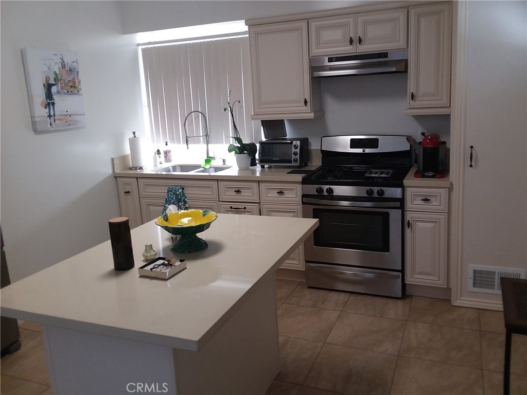 a kitchen with a sink a stove and cabinets