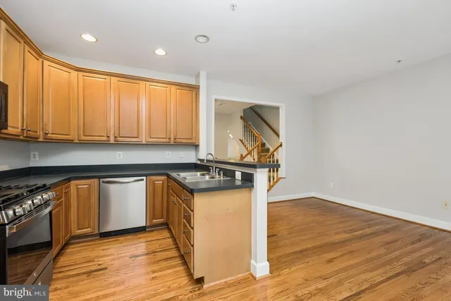 a kitchen with granite countertop wooden floors and stainless steel appliances