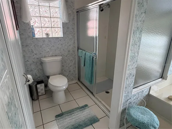 a bathroom with a toilet and a shower