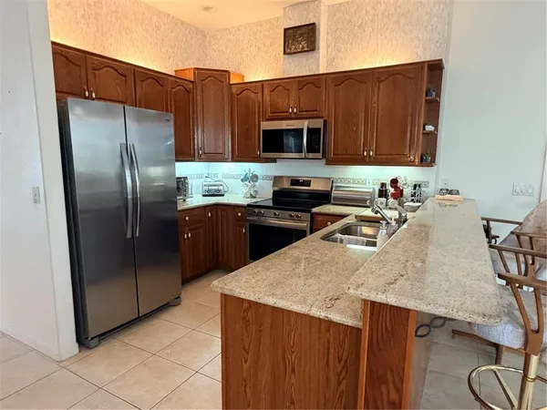a kitchen with stainless steel appliances granite countertop a sink a microwave refrigerator and stove