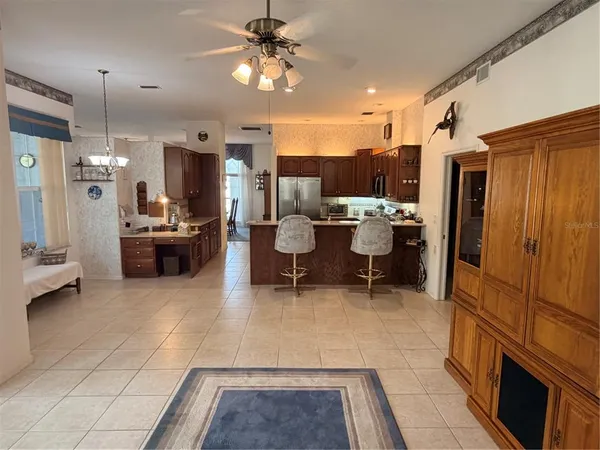 a living room with stainless steel appliances furniture a rug and a view of kitchen