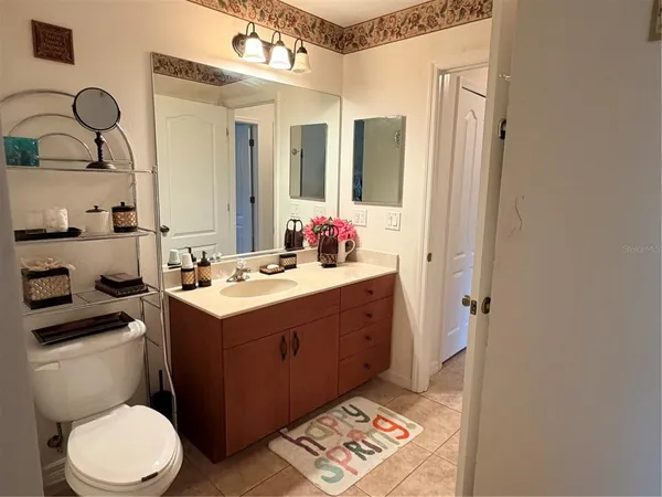 a bathroom with a sink vanity mirror and toilet