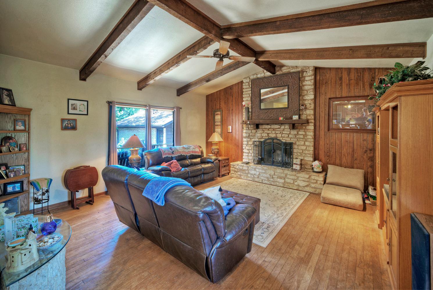 2300 Robin Road Manchaca, TX 78652 - Photo 10 of 36 Exposed wood beams and a classic stone fireplace highlight this warm, welcoming gathering space.