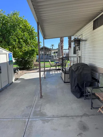 a view of a patio with a table and chairs under an umbrella