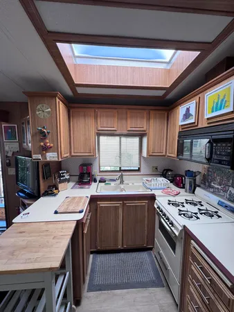 a kitchen with a sink a stove cabinets and a dining table