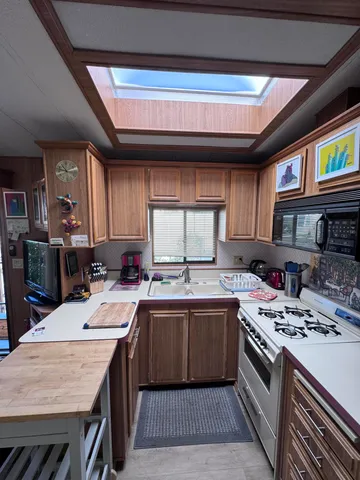 a kitchen with a sink a stove cabinets and a dining table