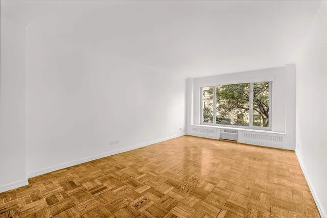a bedroom with a bed and large windows